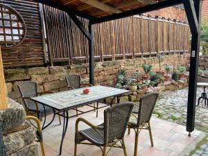 a patio with a table and chairs and a stone wall at Villa Dornröschen Grebenstein in Grebenstein