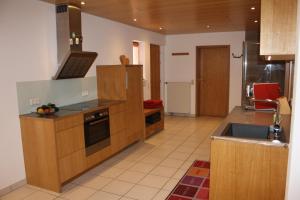 a large kitchen with wooden cabinets and a sink at Apartment mit Sauna in Frickingen
