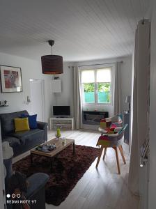 a living room with a couch and a table at LE CLOS DES COMPROMIS in Torsac