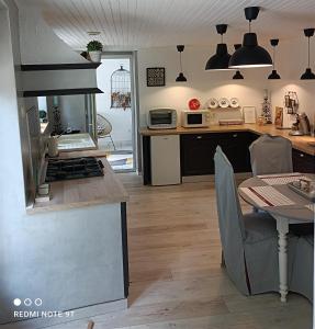 a kitchen with a stove top oven next to a table at LE CLOS DES COMPROMIS in Torsac