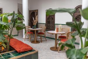 una habitación con mesas, sillas y plantas en Riad Babouchta & Spa, en Marrakech 37 fotos más