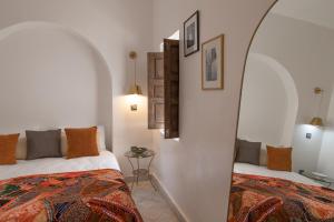 Un dormitorio con dos camas y un espejo. en Riad Babouchta & Spa, en Marrakech