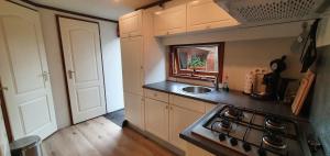 a small kitchen with a stove and a sink at Gezellig chalet Doornspijk o11 - Recreation Only in Doornspijk