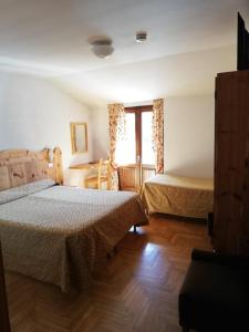 a bedroom with two beds and a window at Hotel Gufo in Bormio