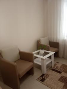 a living room with two chairs and a table at Modern appartment near Sofievka in Umanʼ