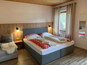 duże łóżko w pokoju z oknem w obiekcie Pension & Apartments Waldkrieber w mieście Presseggersee