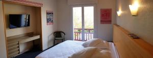 1 dormitorio con 1 cama, TV y ventana en Hotel Pyrenées Atlantique, en Saint-Pée-sur-Nivelle