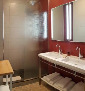 La salle de bains est pourvue d'un lavabo et d'un miroir. dans l'établissement Hotel Pyrenées Atlantique, à Saint-Pée-sur-Nivelle