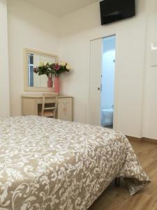 a bedroom with a bed with a brown and white bedspread at Hotel Flora in Alba Adriatica