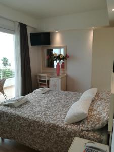 a bedroom with a bed with pillows and a window at Hotel Flora in Alba Adriatica