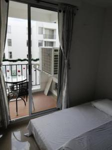 a bedroom with a bed and a balcony with a table at Apartamento vacacional amplio, cómodo y tranquilo. in Ricaurte +23 photos