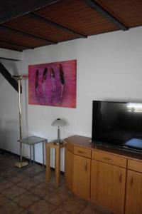 a living room with a flat screen tv on a cabinet at Ferienwohnungen Federleicht in Wermelskirchen