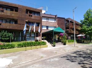 un edificio de ladrillo con banderas delante de él en Hotel Solar del Acuario, en Salto