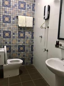 a bathroom with a toilet and a sink and a phone at Hotel VGO in Kuala Lumpur