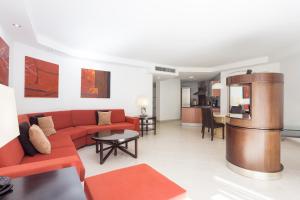 sala de estar con sofá rojo y mesa en Atlas Suites Tenerife by EnjoyaHome, en Los Cristianos