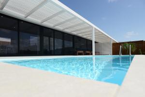 a swimming pool in front of a building at Duna Colorada in La Oliva