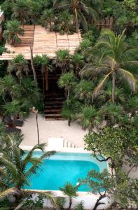 a beach with a pool and a balcony at Diamante K in Tulum