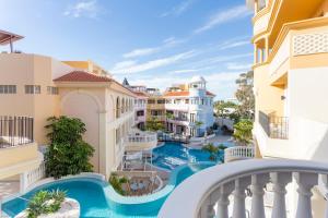 vistas a la piscina desde el balcón de un edificio en Atlas Suites Tenerife by EnjoyaHome, en Los Cristianos