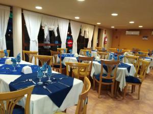 un comedor con mesas y sillas con mantel azul en Hotel Solar del Acuario, en Salto