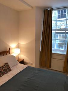 een slaapkamer met een bed en een groot raam bij The Edmonstone's Residence in Edinburgh