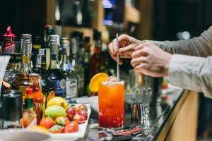 eine Person macht einen Drink an einer Bar in der Unterkunft Dear Hotel Madrid in Madrid