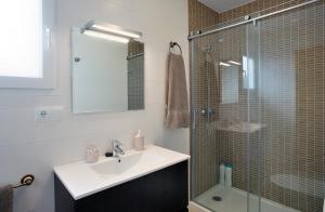ein Bad mit einem Waschbecken und einer Glasdusche in der Unterkunft Apartamentos Ronda Luz in Ronda
