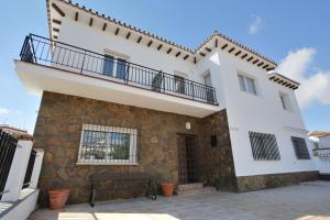 a large white house with a balcony at Apartamentos Rondaluz in Ronda