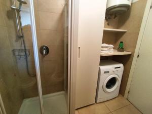 a bathroom with a shower and a washing machine at Soggiorno ai Portici in Vimercate