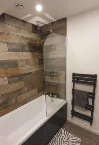 a bathroom with a tub and a glass shower at Stamford - Entire 1 bed cosy home. in Stamford