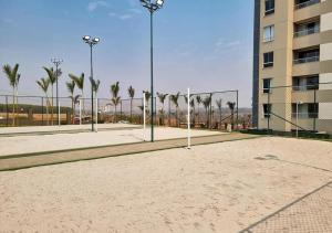 a volleyball court with palm trees and a building at SOLAR DAS AGUAS PARQUE RESORT in Olímpia