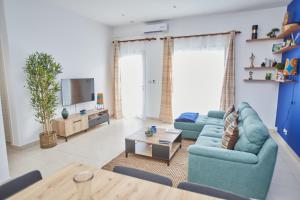 sala de estar con 2 sofás azules y TV en Superbe vue sur océan en Pointe-Noire
