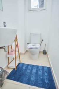 a bathroom with a toilet and a blue rug at Superbe vue sur océan in Pointe-Noire