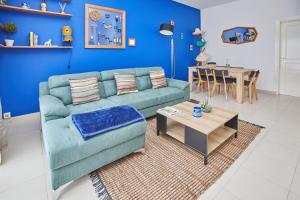 a living room with a blue couch and a table at Superbe vue sur océan in Pointe-Noire