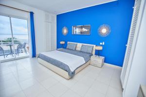 - une chambre bleue avec un lit et un balcon dans l'établissement Superbe vue sur océan, à Pointe-Noire