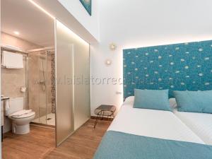a bedroom with a bed and a toilet and a shower at La Isla , tu hogar en Torre del Mar. in Torre del Mar