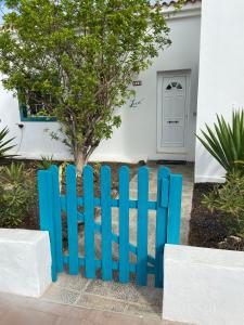 a blue fence in front of a house at Villa Leon in Caleta De Fuste