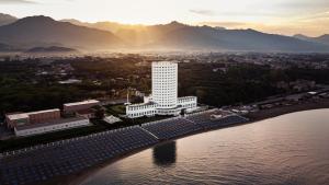 an aerial view of a white building next to the water at Villaggio Torre Marina in Marina di Massa