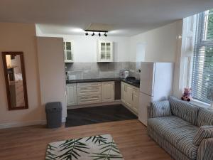 a living room with a couch and a kitchen at Self Contained studio flat in Winterton Hall in Great Yarmouth