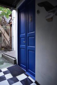eine blaue Tür in einem Gebäude mit kariertem Boden in der Unterkunft chio's place in Tbilisi City