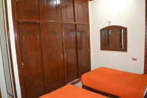 um quarto com 2 camas e um grande armário de madeira em Kulih Nubian House em Shellal