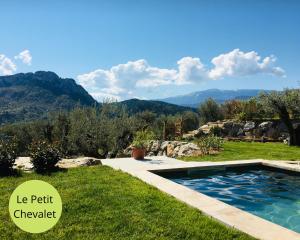 a pool in the grass with mountains in the background at LOGIS DES ROCHES - 2 VILLAS VUE EXCEPTIONNELLE - Le Petit Chevalet, Le Grand Sabouillon in Buis-les-Baronnies