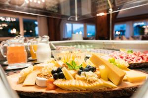een bord kaas en andere voedingsmiddelen op tafel bij Hotel Alpenhof in Unterbäch