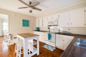 cocina con armarios blancos y ventilador de techo en Spacious beach home ready for Family Memories!, en Point Pleasant Beach