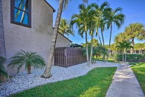 a house with palm trees and a fence at Chic Fort Myers Escape with Community Perks! in Fort Myers