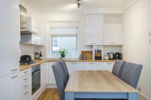 une cuisine avec une table en bois et des chaises bleues dans l'établissement Marylebone Mews - Beautiful 2 bedroom flat, à Londres