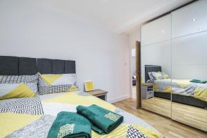 - une chambre avec 2 lits et un miroir dans l'établissement Marylebone Mews - Beautiful 2 bedroom flat, à Londres