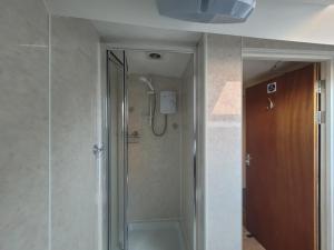 a shower with a glass door in a bathroom at Large 5 bed town-centre home close to the beach, sleeps 9 in Aberystwyth +26 photos