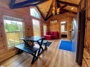 Carroll的住宿－B1 NEW Awesome Tiny Home with AC Mountain Views Minutes to Skiing Hiking Attractions，厨房以及带桌子和冰箱的客厅。