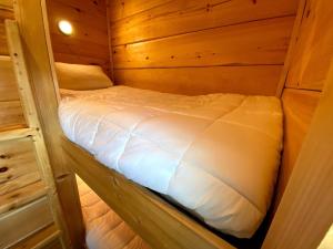 a small bed in a wooden cabin at B1 NEW Awesome Tiny Home with AC Mountain Views Minutes to Skiing Hiking Attractions in Carroll
