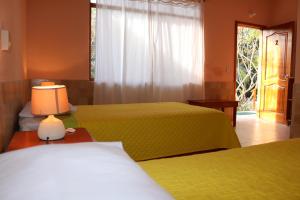 a hotel room with two beds and a window at Cartago Bay in Puerto Villamil